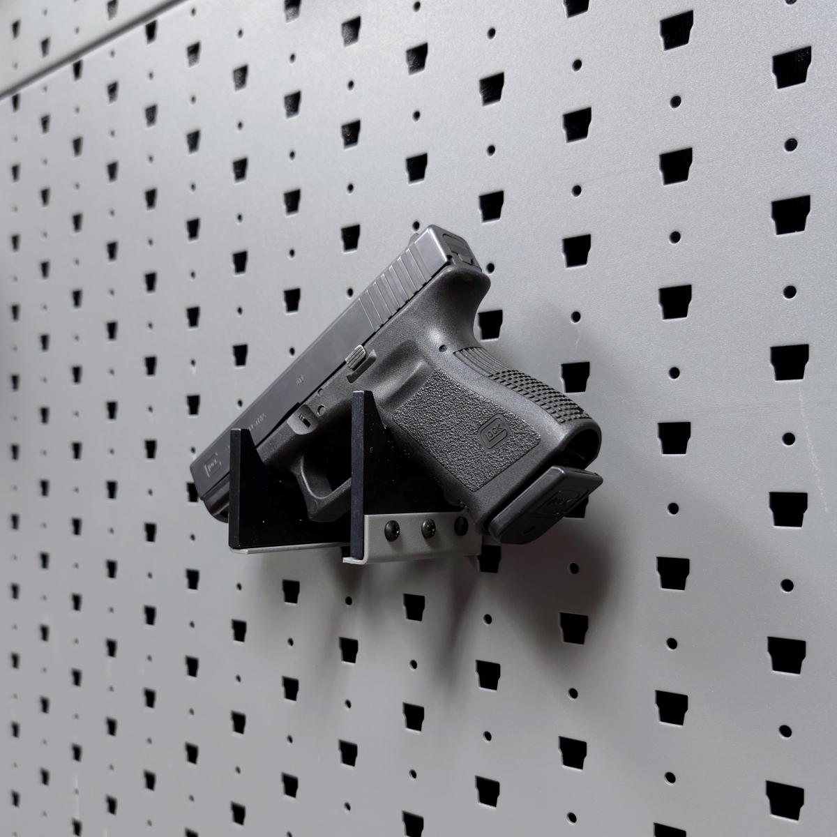Horizontal pistol hanger mounted on GallowTech wall panel holding a handgun at a right angle