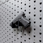 Horizontal pistol hanger mounted on GallowTech wall panel holding a handgun at a right angle