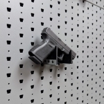Hybrid Handgun Hanger Right holding a handgun, right-facing mount on Gallow wall panel