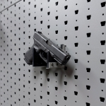 Hybrid Handgun Hanger Right holding a handgun, right-angle view on Gallow wall panel