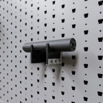 Medium horizontal suppressor hanger holding rifle suppressor, right-angle view